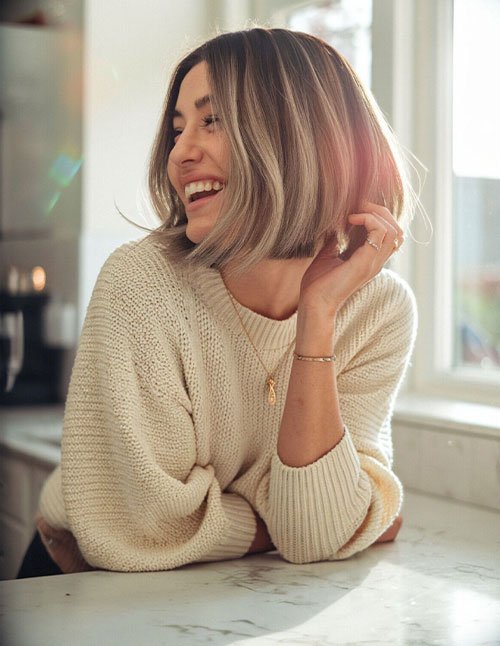 Woman with a jaw-length layered bob and center-parted face-framing pieces.