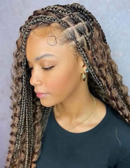 Long box braids with a side part, featuring curly loose pieces blended through the braids and flowing curls at the ends.