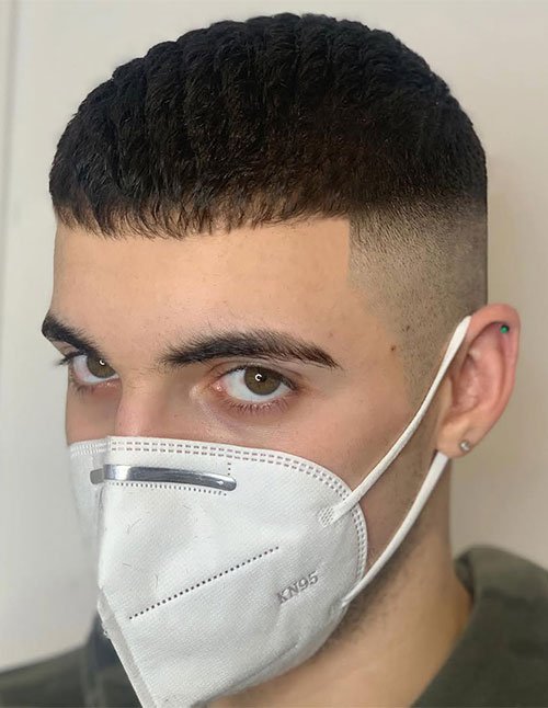 Man wearing a long Caesar haircut with a slightly extended textured fringe and clean faded sides.