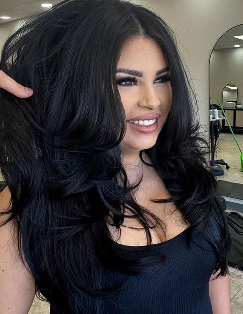 Long dark hair with big, bouncy layers and a voluminous blowout finish.