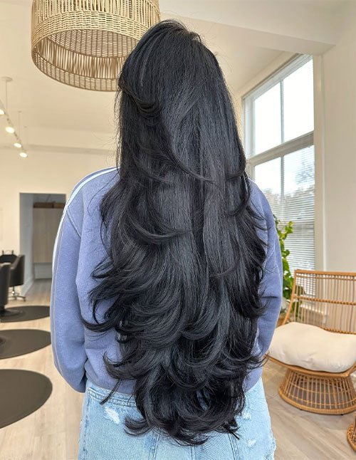 Back view of long layered hair with smooth, blended layers and soft curved ends for a full, flowing shape.
