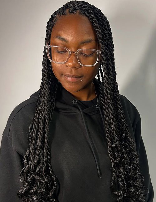Long Senegalese twists styled neatly with smooth rope-like texture and softly curled ends, worn loose over the shoulders.