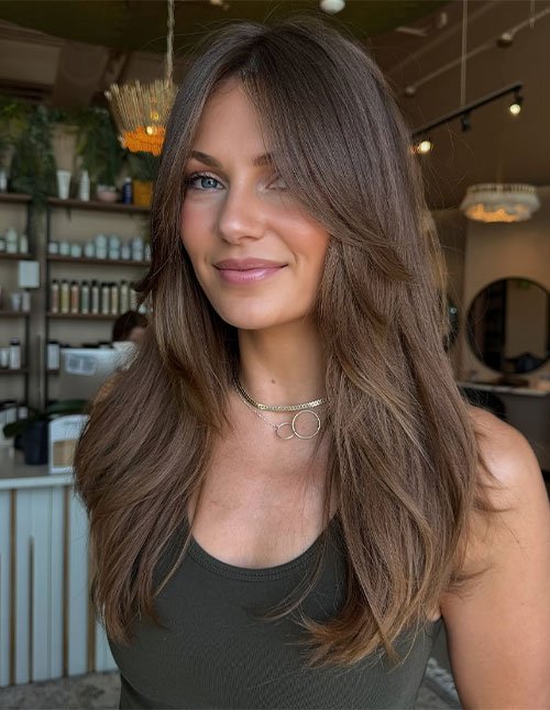 Woman with medium-length layered hair styled in a classic, soft, and natural finish.