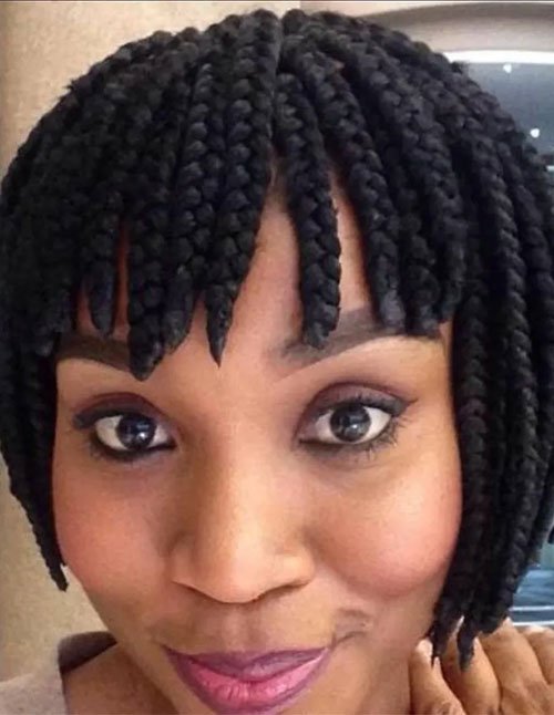 Short box braid bob with thick braided bangs framing the forehead.