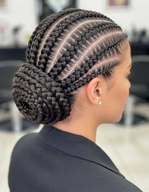 Protective braided bun hairstyle with clean cornrows and thick feed-in braids wrapped into a low braided bun at the nape.
