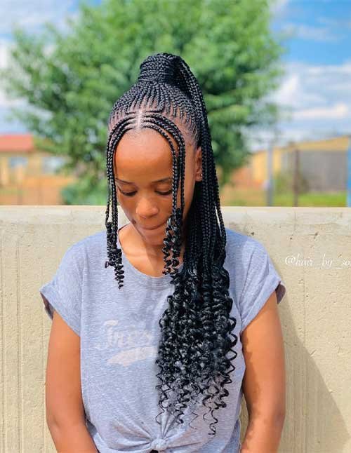 Girl wearing a high braided ponytail with neat cornrow-style braids and curly ends, looking down outdoors.