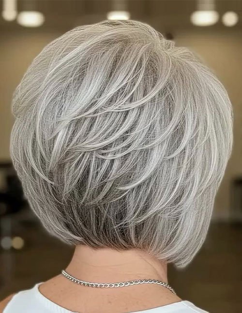 Back view of short stacked bob with volume lift and silver-gray hair