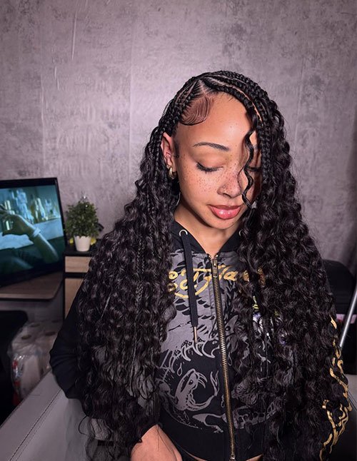 Side-part Fulani braids with neat scalp braids and long, loose curls, finished with laid baby hairs.