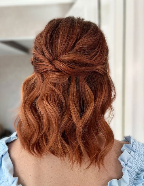 Simple half-up hairstyle on short wavy hair with softly twisted sections pinned at the back.