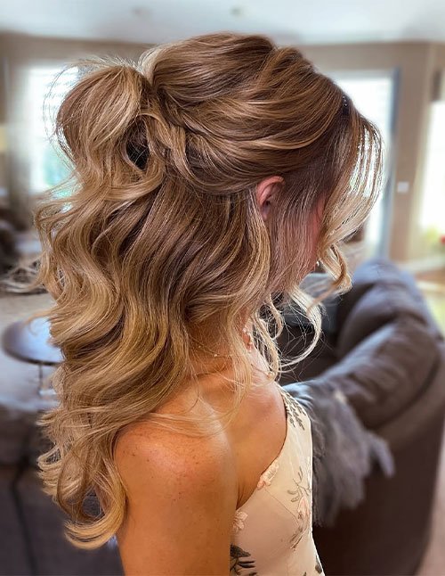 Simple half updo on short wavy hair with soft volume and loose curls.