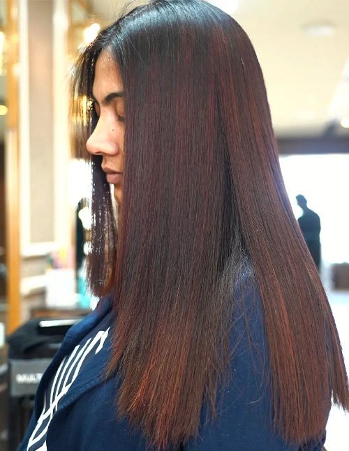 Side view of Sleek Straight Haircut with long, straight hair and a smooth, glossy finish.