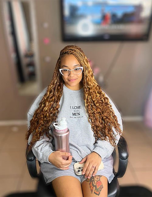 Soft golden twist braids with a side-swept top section and long wavy lengths, blending small twists into loose textured curls.