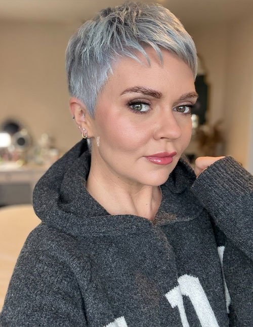 Woman with a soft tapered pixie haircut in icy silver color.