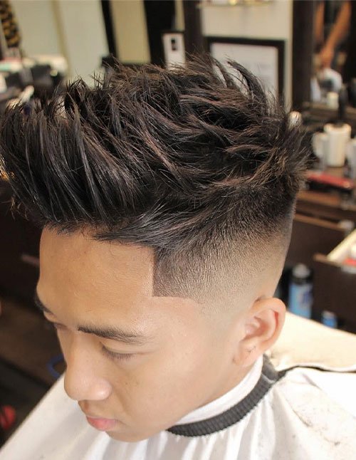 Man with spiky textured hair on top, featuring a high fade on the sides and a sharp hairline.