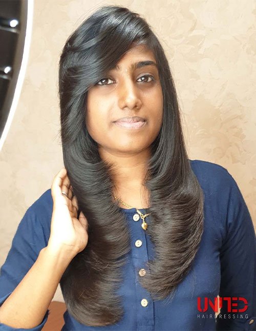 Woman with long, smooth hair and tapered side-swept bangs.