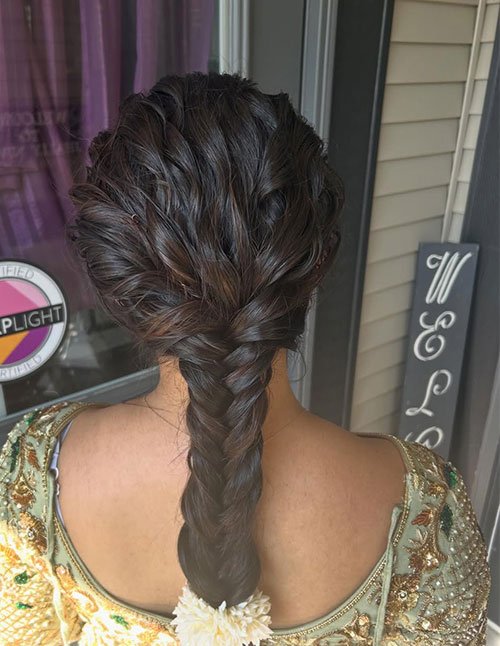 Textured braid hairstyle with a voluminous, softly pulled braid that starts wide at the crown and continues down the back.