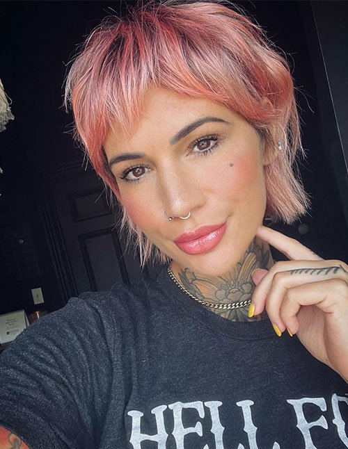 Person with textured short fringe and pink-toned short haircut.