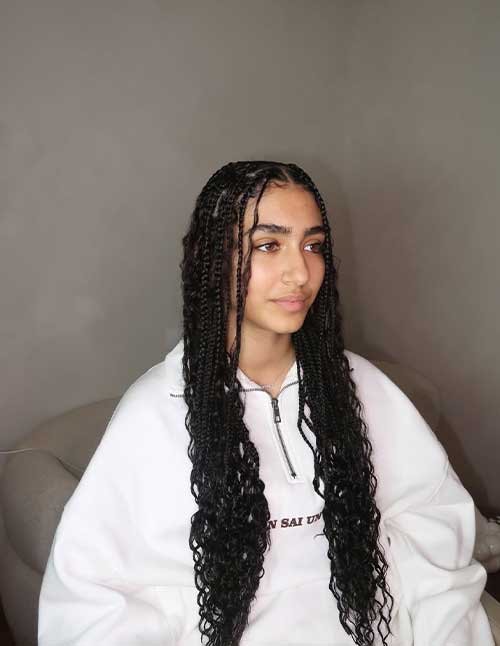 Timeless classic braids styled in a neat center part with long braids flowing into soft, loose curls.