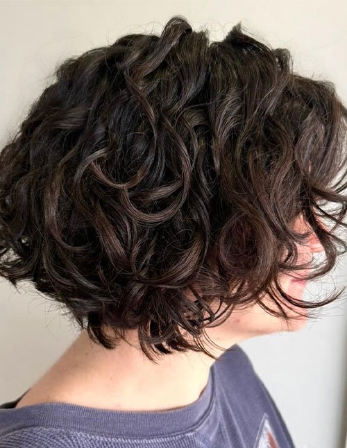 Voluminous curly bob with soft waves and side-swept layers