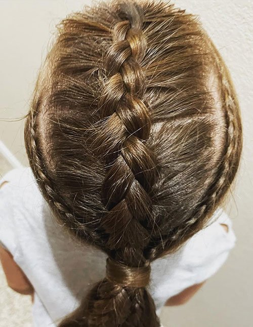 Top view of hair styled with a wide center Dutch braid and two small side braids, gathered into a low ponytail.